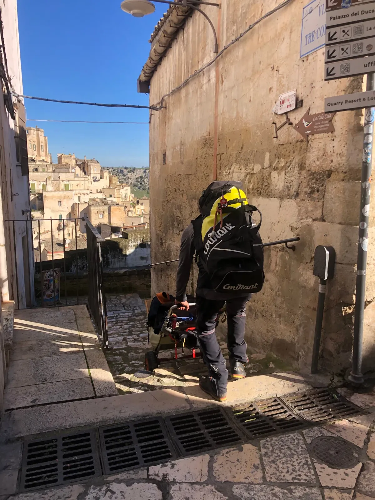 Arboricoltore con zaino e carrello tra i vicoli dei Sassi