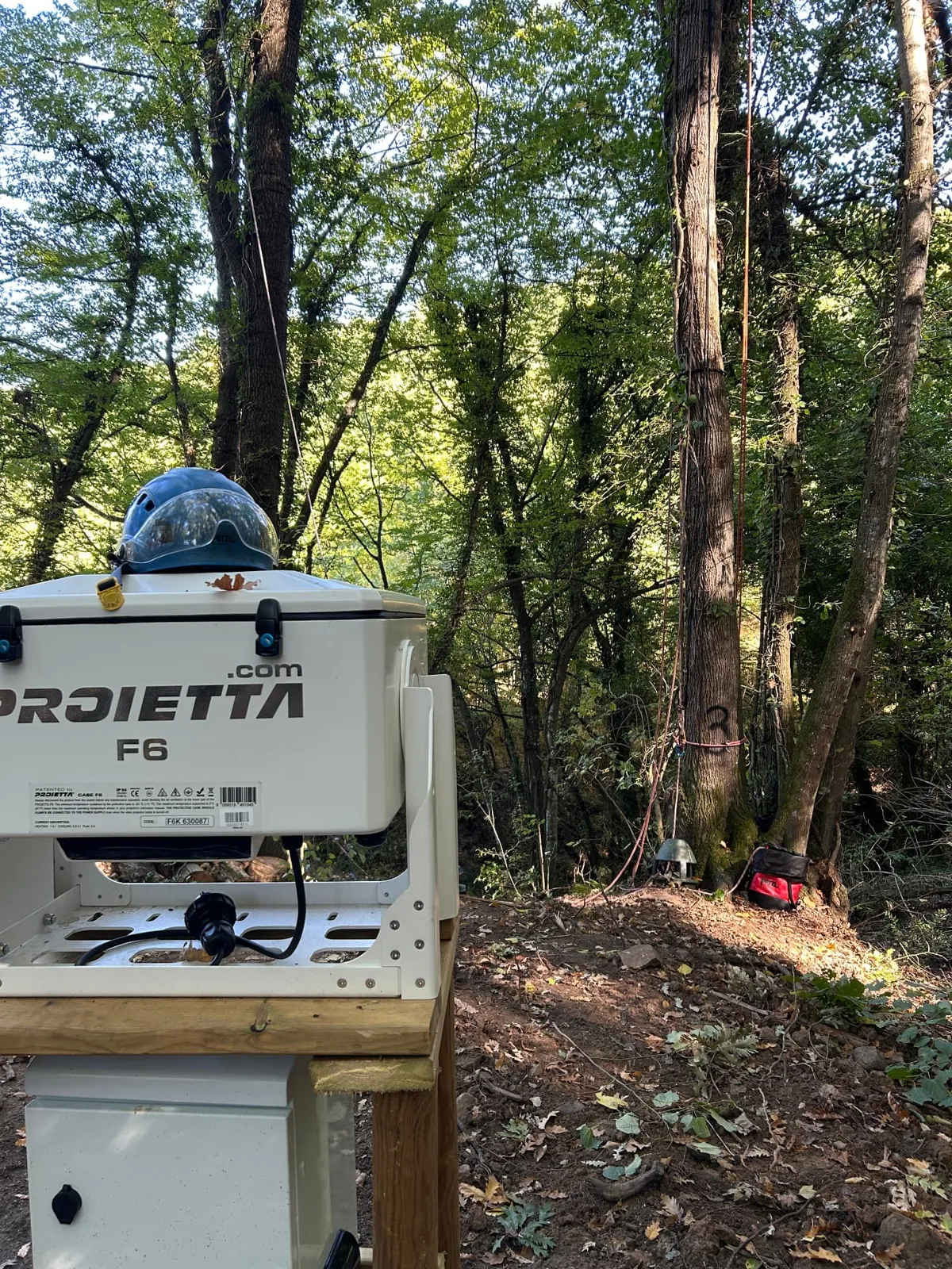 Cabina del proiettore con casco da arrampicata e cerri sullo sfondo
